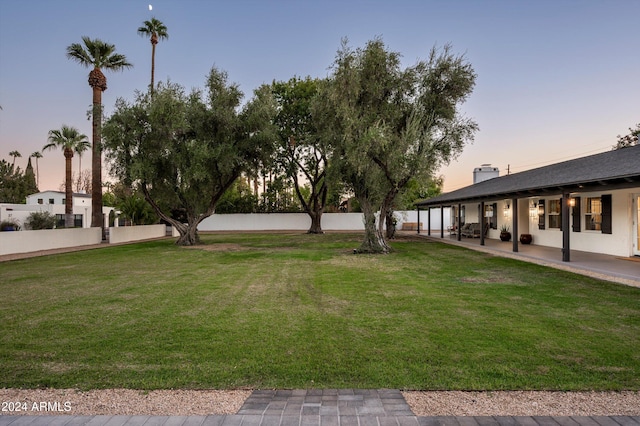 yard at dusk featuring a patio