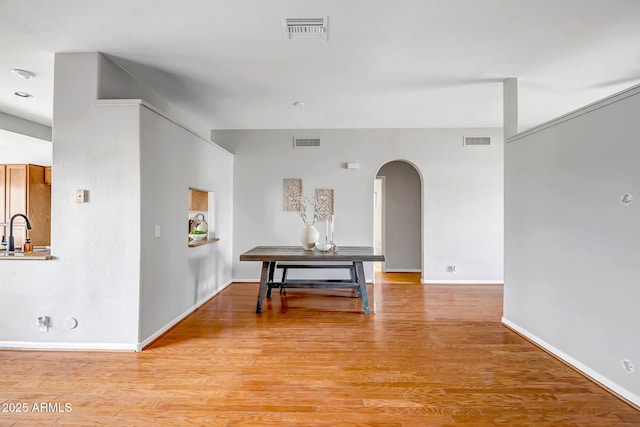 10215 W Missouri Ave, Glendale, AZ 85307 - hallway featuring arched walkways, light wood finished floors, a sink, and baseboards