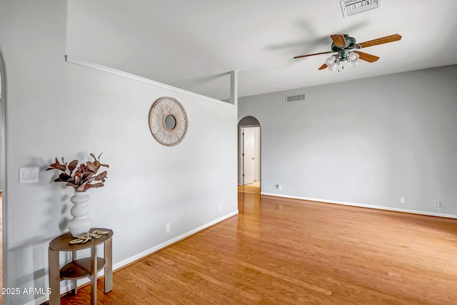 10215 W Missouri Ave, Glendale, AZ 85307 - spare room featuring arched walkways, ceiling fan, wood finished floors, and baseboards