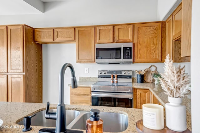 10215 W Missouri Ave, Glendale, AZ 85307 - kitchen featuring appliances with stainless steel finishes, light stone countertops, and a sink