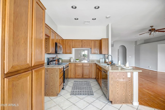 10215 W Missouri Ave, Glendale, AZ 85307 - kitchen featuring stainless steel appliances, a sink, arched walkways, a peninsula, and ceiling fan