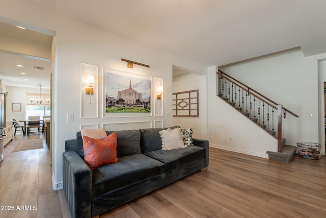 living room with wood finished floors, stairs, a chandelier, recessed lighting, and baseboards