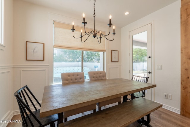 dining area with a decorative wall, wood finished floors, a chandelier, wainscoting, and recessed lighting