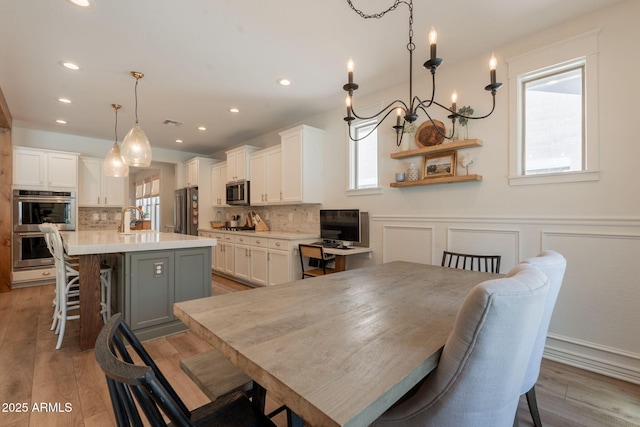 dining space with recessed lighting and light wood-style flooring