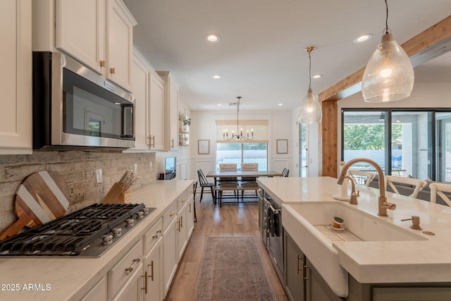 kitchen featuring appliances with stainless steel finishes, wood finished floors, light countertops, a chandelier, and recessed lighting