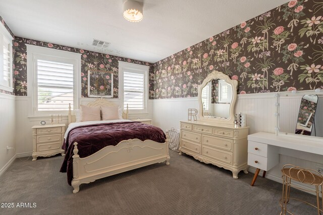 carpeted bedroom featuring wainscoting, wallpapered walls, and multiple windows
