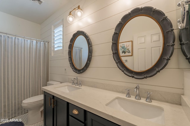 full bathroom featuring toilet and double vanity