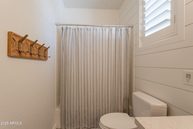 bathroom featuring toilet, shower / bath combination with curtain, and vanity