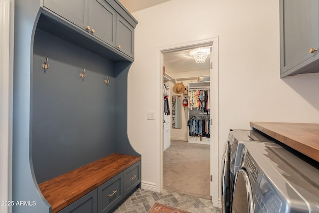 mudroom with separate washer and dryer and baseboards