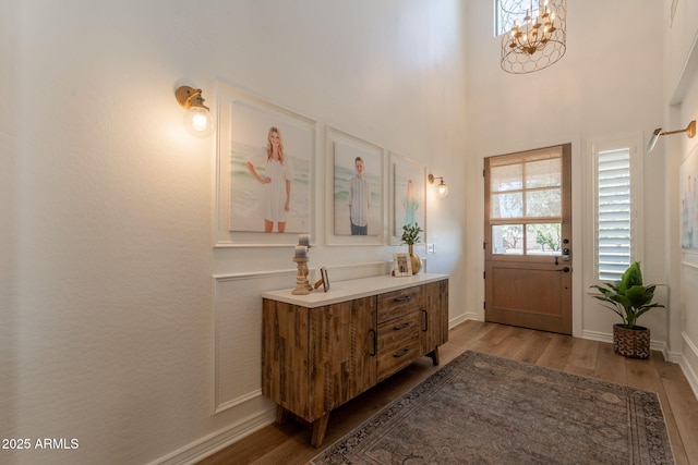 bathroom featuring wood finished floors, a chandelier, vanity, and baseboards