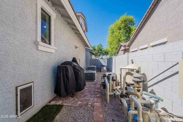 view of yard featuring fence and central AC