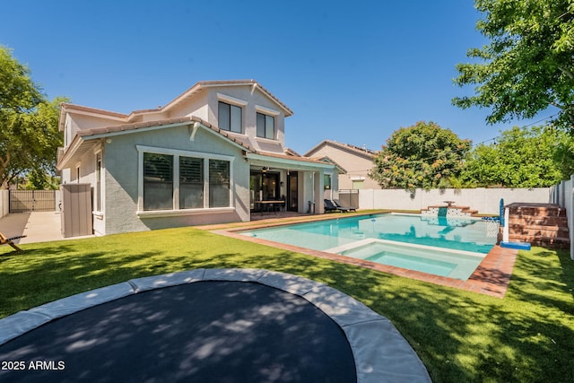 back of property with stucco siding, a patio, and a pool with connected hot tub