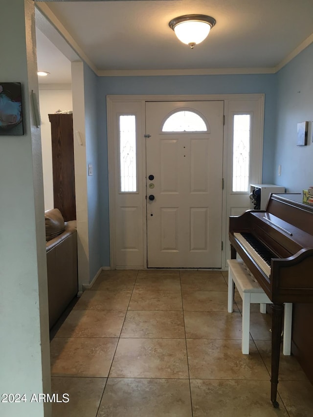 entrance foyer featuring light tile patterned floors and crown molding