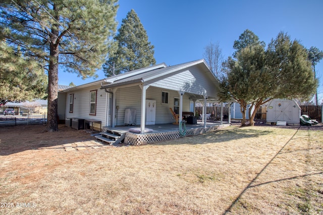 back of house with a lawn, a patio, a shed, fence, and an outdoor structure