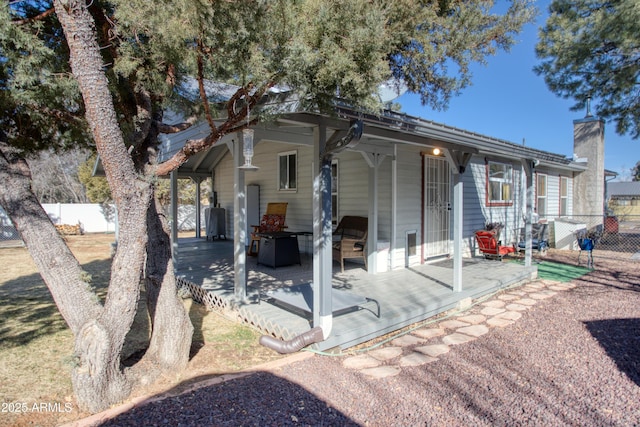 back of property featuring a patio area, a chimney, and fence