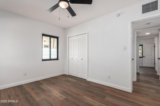 unfurnished bedroom with ceiling fan, dark hardwood / wood-style floors, and a closet