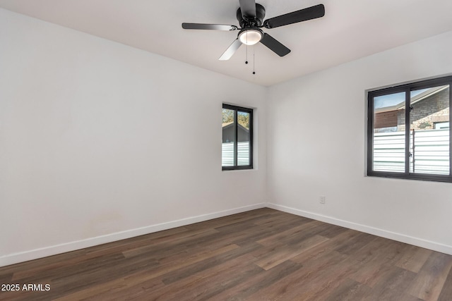 empty room featuring ceiling fan, baseboards, and dark wood-type flooring