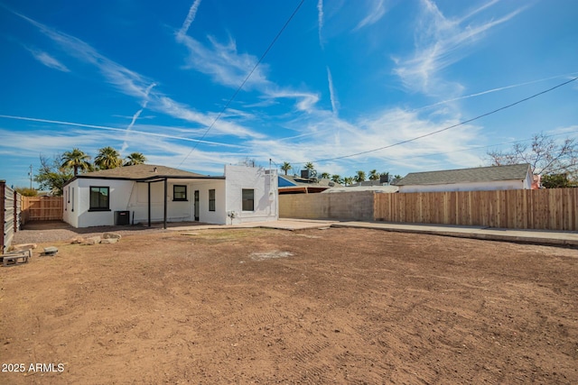 rear view of house featuring cooling unit, a patio area, a fenced backyard, and stucco siding