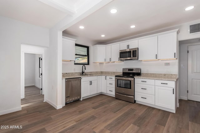 kitchen with appliances with stainless steel finishes, visible vents, and white cabinets