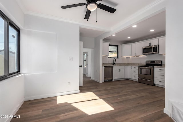 kitchen with light stone counters, dark wood finished floors, visible vents, appliances with stainless steel finishes, and white cabinetry