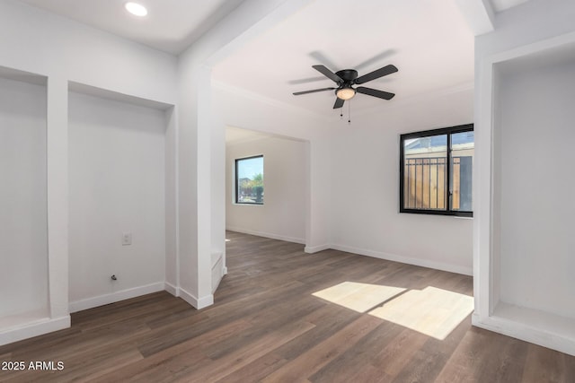 unfurnished room with a healthy amount of sunlight, baseboards, and dark wood finished floors