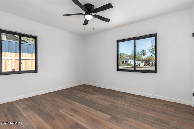 spare room with dark wood-style floors, ceiling fan, and baseboards