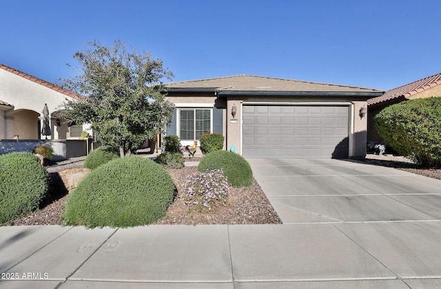 view of front of house featuring driveway, a garage, and stucco siding