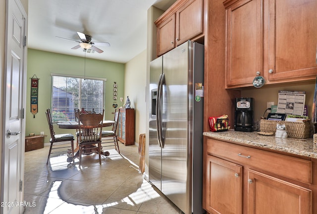 kitchen with brown cabinets, ceiling fan, stainless steel refrigerator with ice dispenser, and light tile patterned flooring