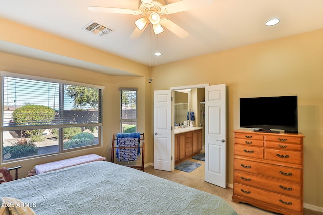 bedroom with recessed lighting, light carpet, visible vents, baseboards, and ensuite bath