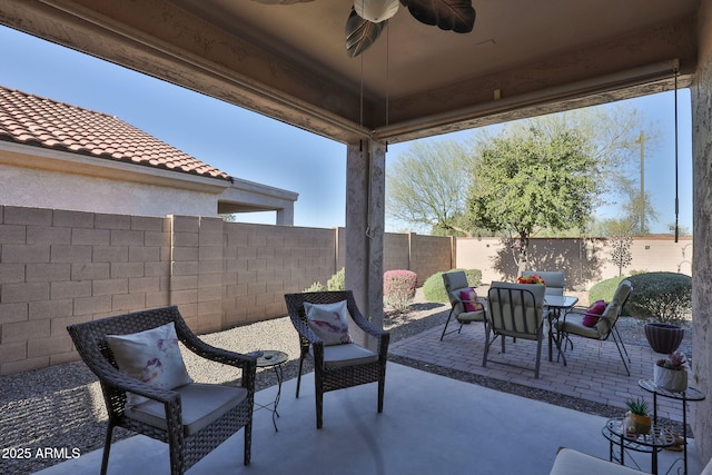 view of patio / terrace featuring outdoor dining area, a fenced backyard, and a ceiling fan