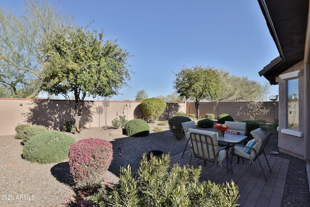 view of yard featuring outdoor dining space, a fenced backyard, and a patio