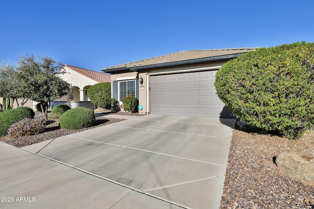 view of front facade featuring an attached garage, concrete driveway, and stucco siding