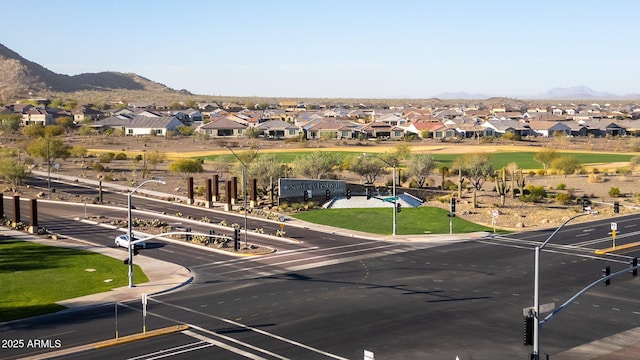 view of street with street lighting, a residential view, a mountain view, and curbs