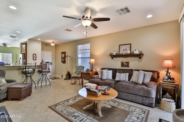 living area featuring ceiling fan, light tile patterned flooring, and visible vents