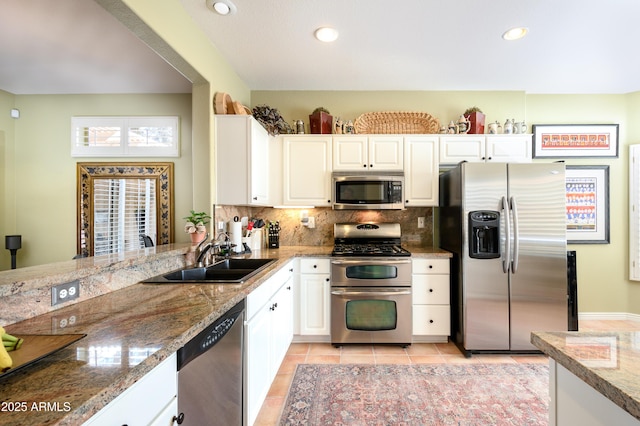 kitchen with backsplash, stainless steel appliances, sink, and white cabinets