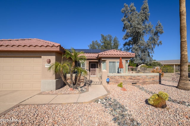 view of front of property featuring a garage and solar panels