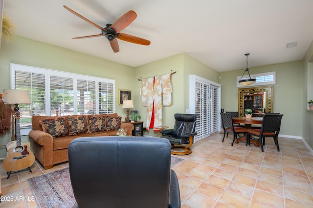 tiled living room featuring ceiling fan and a healthy amount of sunlight