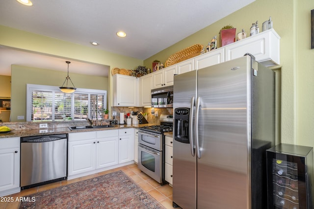 kitchen with wine cooler, appliances with stainless steel finishes, sink, and white cabinets