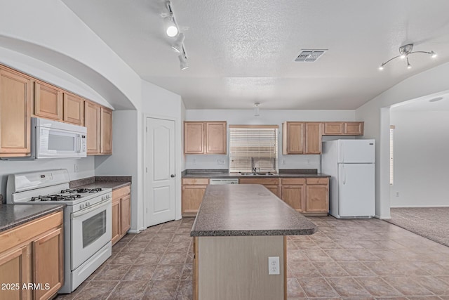 708 E Mule Train Trl, San Tan Valley, AZ 85143 - kitchen with lofted ceiling, a kitchen island, dark countertops, white appliances, and a sink