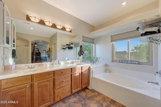 bathroom with shower with separate bathtub, vanity, and ceiling fan