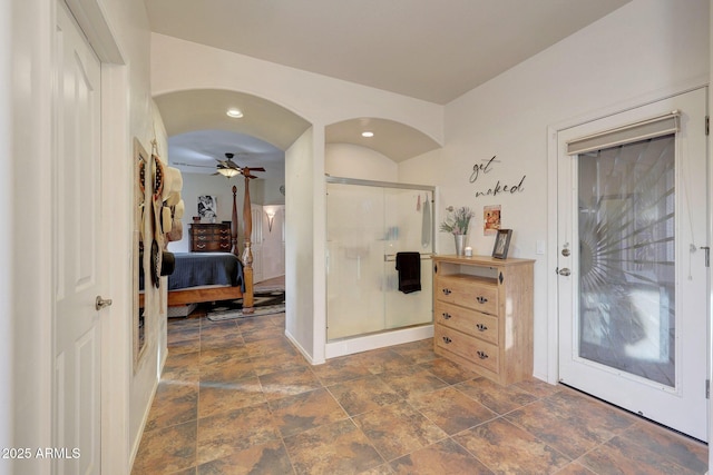 bathroom with ceiling fan and an enclosed shower