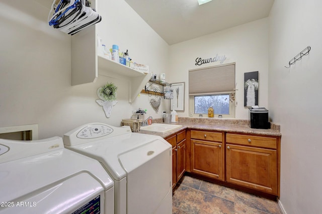 clothes washing area with cabinets, washing machine and dryer, and sink