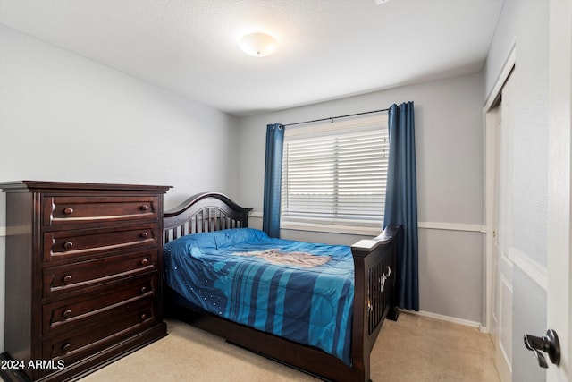 bedroom with a closet and light colored carpet