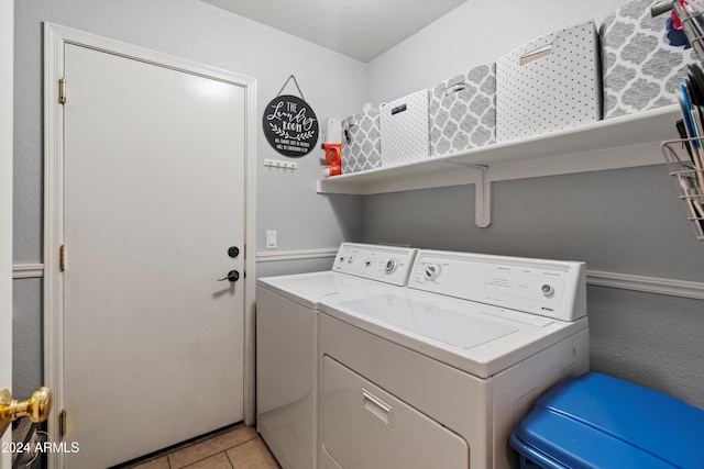 washroom with light tile patterned floors and washing machine and dryer