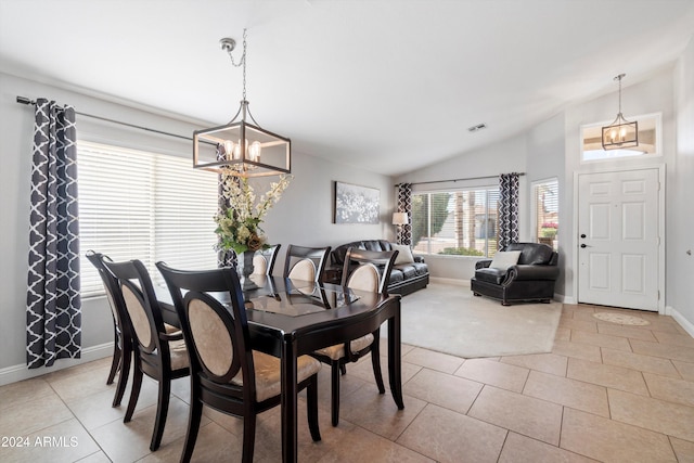 tiled dining space featuring vaulted ceiling