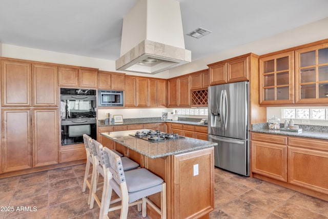 7524 E Leland Cir, Mesa, AZ 85207 - kitchen with appliances with stainless steel finishes, ventilation hood, light stone counters, a breakfast bar area, and a kitchen island