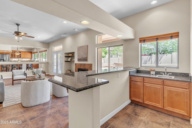 7524 E Leland Cir, Mesa, AZ 85207 - kitchen with a sink, open floor plan, baseboards, a fireplace, and a peninsula