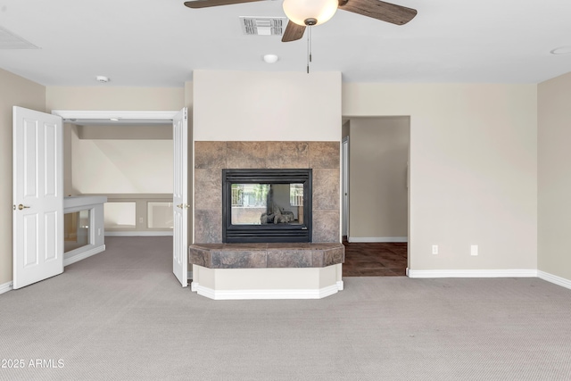 7524 E Leland Cir, Mesa, AZ 85207 - unfurnished living room featuring carpet flooring, a ceiling fan, a tiled fireplace, and baseboards