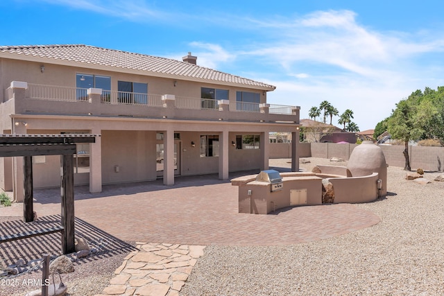 7524 E Leland Cir, Mesa, AZ 85207 - rear view of house with an outdoor kitchen, fence, a balcony, a patio area, and stucco siding
