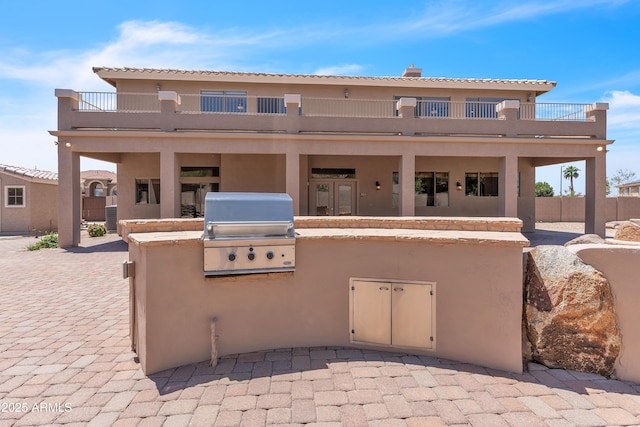 7524 E Leland Cir, Mesa, AZ 85207 - rear view of house with an outdoor kitchen, a balcony, a patio, and stucco siding